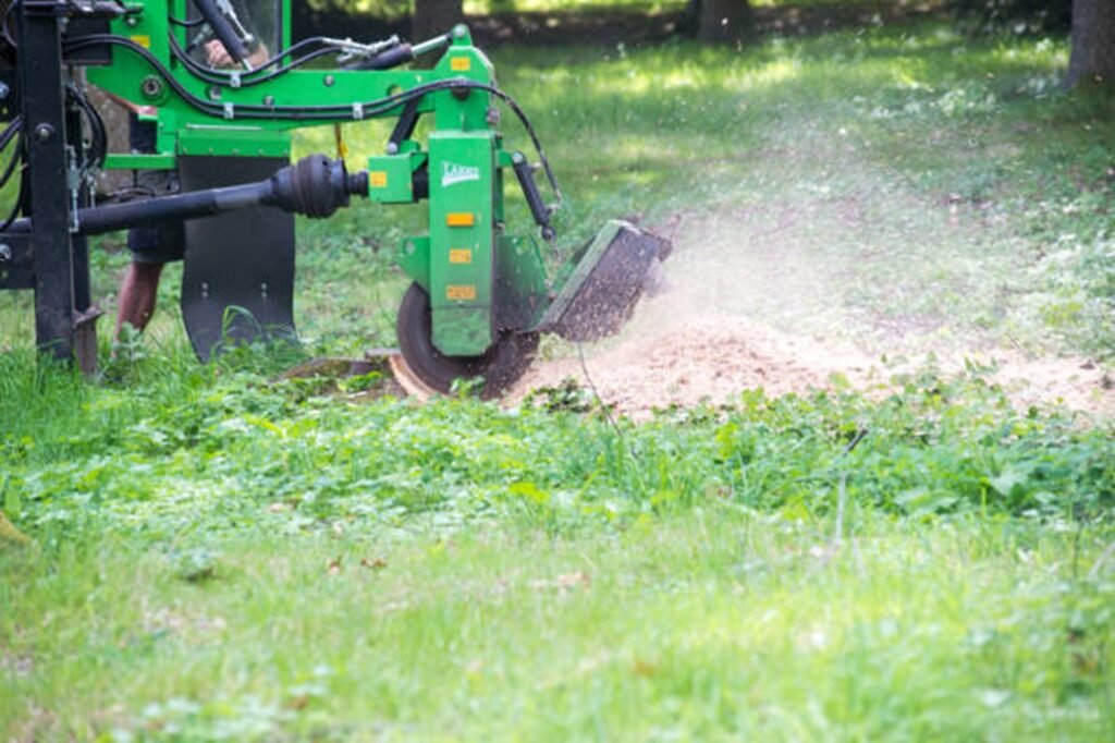 Professional stump grinding machine removing a tree stump below ground level during stump grinding and removal service in University City, MO.